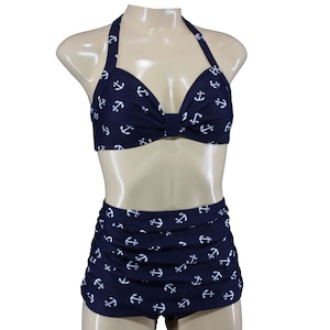 May include: A navy blue swimsuit with a halter top and high-waisted bottoms. The swimsuit is covered in a white anchor print.