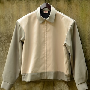 May include: A beige and gray zip-up jacket with a ribbed waistband and cuffs.