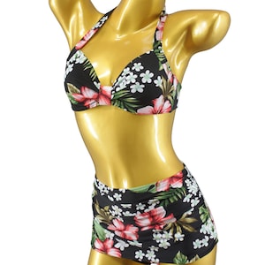 Può includere: Un costume da bagno a due pezzi con sfondo nero e motivo floreale di fiori rosa, bianchi e verdi. La parte superiore è a fascia, e la parte inferiore è a vita alta.