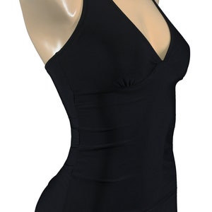 May include: A black halter-style swimsuit with a V-neckline and a high-cut leg.