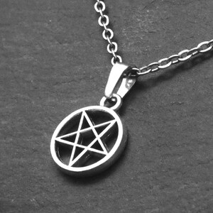 May include: A silver chain necklace with a pendant featuring a pentagram, a five-pointed star, inside a circle.
