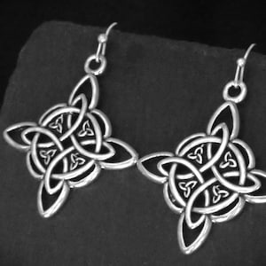 May include: Silver Celtic knot earrings with a detailed design. The earrings are dangle style with a hook fastening.