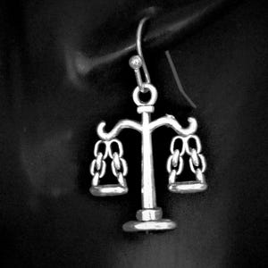 May include: A set of three ceramic mugs with a speckled, matte finish. The mugs are in shades of cream, light gray, and dark gray. Each mug has a simple, minimalist design and a rounded handle. The mugs are stacked on top of each other.