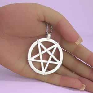 May include: Silver pendant necklace featuring a pentagram, or five-pointed star, inside a circle.