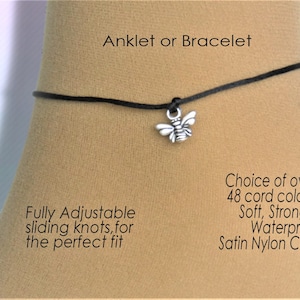以下が含まれることがあります： 銀色の蜂のチャームが付いた、調節可能な黒色のアンクレットまたはブレスレット。コードはサテンナイロン製で、48色からお選びいただけます。  アンクレットまたはブレスレット。完全に調節可能なスライドノットで、完璧なフィット感を実現します。 48色以上のコードからお選びいただけます。 ソフト、ストロング、ウォータープルーフ サテンナイロンコード