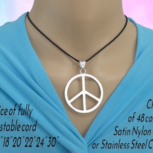 May include: A silver peace sign pendant necklace on a black cord. The necklace is adjustable and comes in lengths of 16, 18, 20, 22, 24, or 30 inches. The cord can also be replaced with a stainless steel chain. The cord is available in 48 colours.