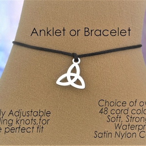 以下が含まれることがあります： 黒いコードのアンクレットまたはブレスレット。シルバーカラーのケルトノットチャーム付き。テキストには、完全に調整可能なスライドノットがあり、柔らかく、強く、防水性のあるサテンナイロンコードで作られていると書かれています。 48色以上のコードをご用意しています。