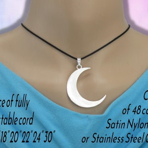 May include: A silver-toned crescent moon pendant suspended on a black cord. Text reads: Choice of fully adjustable cord or 16" 18" 20" 22" 24" 30" and Choice of 48 colours Satin Nylon Cord or Stainless Steel Chain.