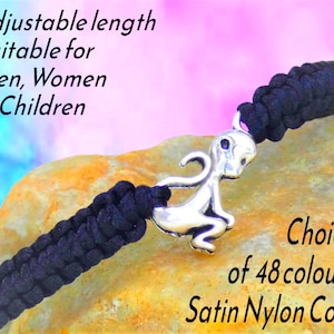 May include: Black satin nylon cord bracelet with a silver alien charm. The bracelet is adjustable and available in 48 colors. Text on the image reads: "Adjustable length Suitable for Men, Women & Children. Choice of 48 colours Satin Nylon Cord."