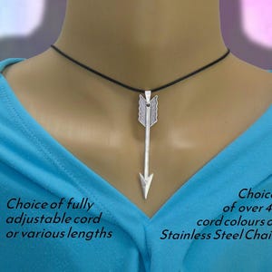 May include: A silver arrow pendant necklace with a black cord. The arrow design has detailed feathering. The text on the image says "Choice of fully adjustable cord or various lengths" and "Choice of over 48 cord colours or Stainless Steel Chain."