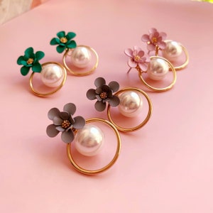 Könnte beinhalten: Ein Set mit vier Paar Ohrringen mit Perlen- und Blumendesign. Die Ohrringe sind in vier Farben erhältlich: Grün, Rosa, Grau und Weiß.