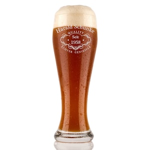 Op de afbeelding: Een hoog, helder glazen bierglas met een gematteerde rand en een witte inscriptie die "Harald Schunke Quality Seit 1958 Echter Geniesser" luidt. Het glas is gevuld met een lichtbruin bier en heeft condensatie aan de buitenkant.