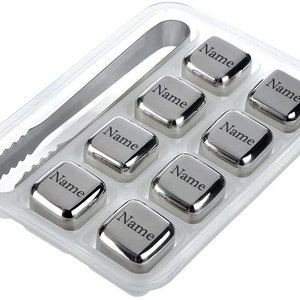 Può includere: Set di otto cubetti di ghiaccio in metallo argentato con la parola "Nome" incisa su ogni cubetto. I cubetti sono in un vassoio di plastica trasparente con una pinza in metallo argentato.