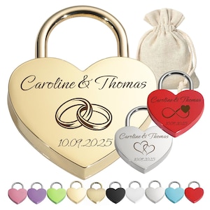 Può includere: Un grande lucchetto dorato a forma di cuore inciso con i nomi Caroline & Thomas, due anelli intrecciati e la data 10.09.2025. Sono inclusi un lucchetto a cuore argentato più piccolo, uno rosso con simbolo dell'infinito e un sacchetto in tessuto.