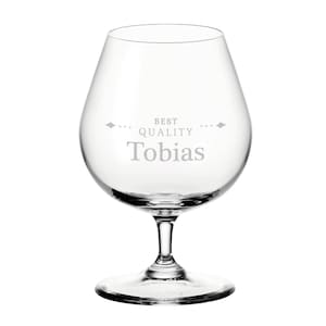 May include: A clear brandy glass with a rounded bowl and a stem. The words "BEST QUALITY Tobias" are etched on the glass. Ideal for brandy or other spirits, this glass is a classic design.
