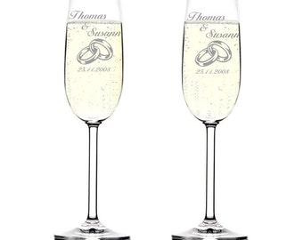 May include: Two clear glass champagne flutes with the names Thomas & Susan and the date 25.11.2008 etched on the front. The flutes are filled with champagne.