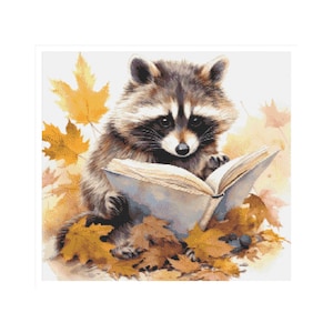 Puede incluir: Un mapache sentado en un montón de hojas de otoño, leyendo un libro. El mapache es marrón y gris con una máscara negra alrededor de los ojos. El libro está abierto y tiene una cubierta blanca.