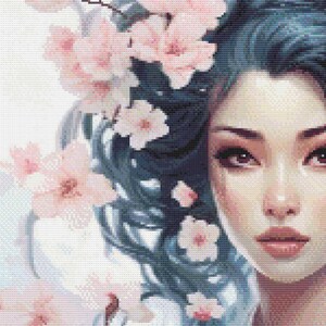 May include: A cross-stitch portrait of a woman with blue hair adorned with pink cherry blossoms. The woman's face is detailed with soft pink and brown tones, creating a serene and delicate aesthetic. The artwork is a close-up, focusing on the face and floral elements.