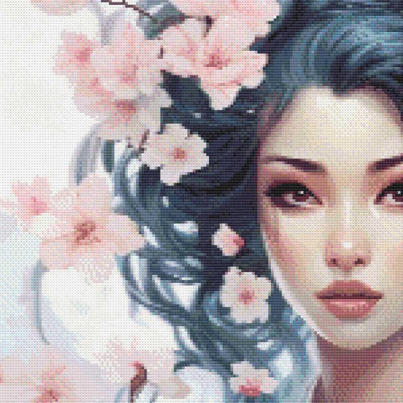 May include: A cross-stitch portrait of a woman with blue hair adorned with pink cherry blossoms. The woman's face is detailed with soft pink and brown tones, creating a serene and delicate aesthetic. The artwork is a close-up, focusing on the face and floral elements.