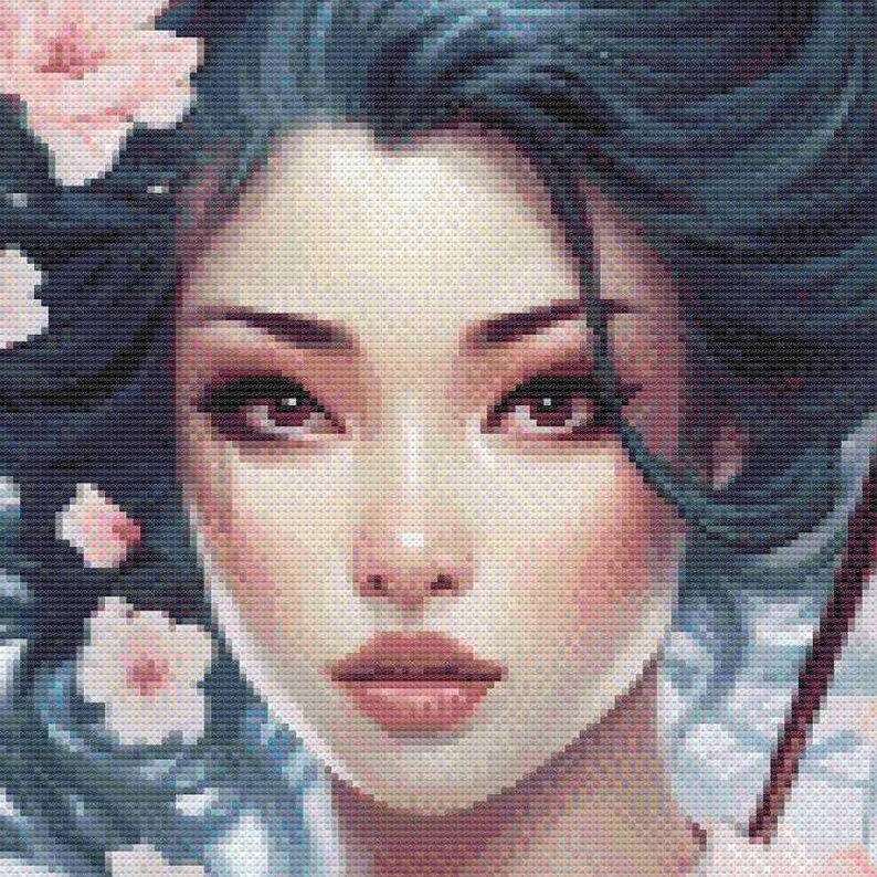 May include: A cross-stitch portrait of a woman with dark hair and eyes, adorned with pink flowers. The woman has a fair complexion with rosy cheeks and lips. The artwork is detailed, with a focus on the woman's face and expression.