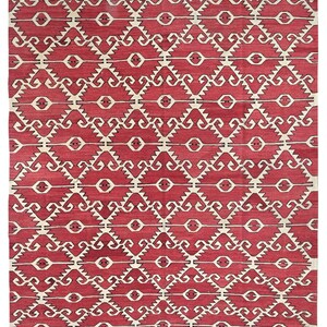Puede incluir: Una alfombra roja y blanca con un patr&oacute;n geom&eacute;trico de dise&ntilde;o tradicional. La alfombra tiene un patr&oacute;n repetitivo de remolinos y diamantes negros y blancos.