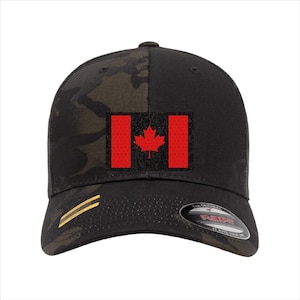 May include: Black and camouflage baseball cap with the Canadian flag. The flag is red with a maple leaf emblem. The cap has a curved peak and a Flexfit design.