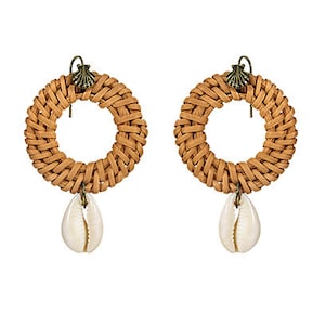 May include: A pair of woven rattan hoop earrings with a shell charm hanging from each hoop. The earrings are in an antique gold tan color.