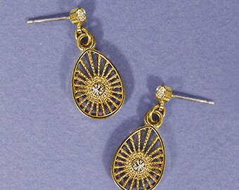 May include: A pair of gold earrings with a delicate, openwork design in the shape of a teardrop. Each earring features a small, clear rhinestone in the center.