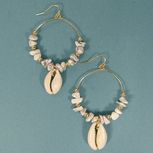 May include: A pair of gold hoop earrings with white shell and stone accents. The earrings are made of a gold-tone metal and feature a white shell charm hanging from each hoop.