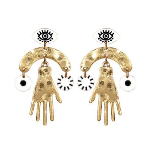 May include: A pair of gold-tone earrings with a white and black eye design, a hand-shaped charm, and a circle charm.