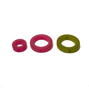 Op de afbeelding: Drie plastic ringen in verschillende maten. De grootste ring is groen, de middelste ring is roze en de kleinste ring is rood.