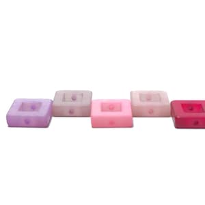 Może przedstawiać: Pięć kwadratowych koralików w kolorze różowym, fioletowym i czerwonym.