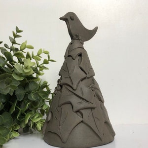 Op de afbeelding: Een bruine keramische kerstboomversiering met een vogel erop. De boom is versierd met bladeren en de vogel heeft een eenvoudig ontwerp.