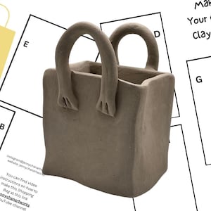 May include: A brown clay tote bag with two handles. The tote bag is sitting on a white surface. The text "Make Your Own Clay Tote" is visible in the background.