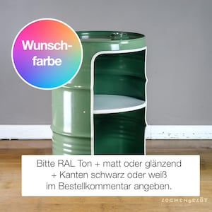 May include: A green metal barrel repurposed as a storage unit. The barrel has a white interior with two shelves and a white trim. The image includes text in German, and a colorful circle with the words "Wunschfarbe".