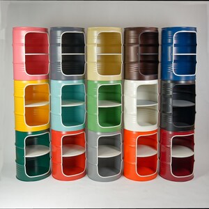 Puede incluir: Una colecci&oacute;n de quince unidades de almacenamiento cil&iacute;ndricas de metal dispuestas en tres filas de cinco. Cada unidad presenta un gran recorte rectangular en la parte frontal, revelando un estante interior. Las unidades est&aacute;n pintadas en varios colores s&oacute;lidos.