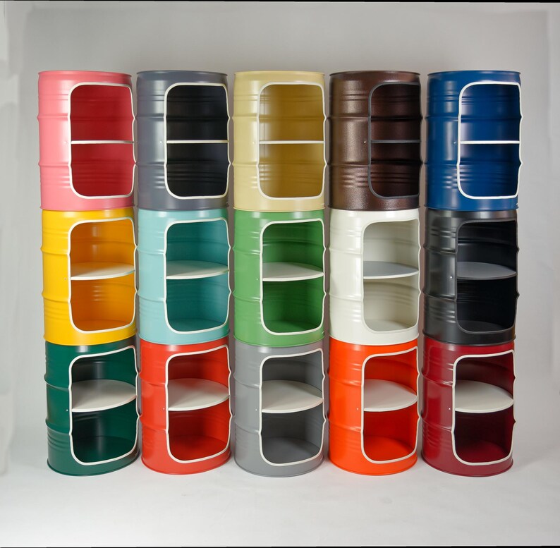 Puede incluir: Una colecci&oacute;n de quince unidades de almacenamiento cil&iacute;ndricas de metal dispuestas en tres filas de cinco. Cada unidad presenta un gran recorte rectangular en la parte frontal, revelando un estante interior. Las unidades est&aacute;n pintadas en varios colores s&oacute;lidos.