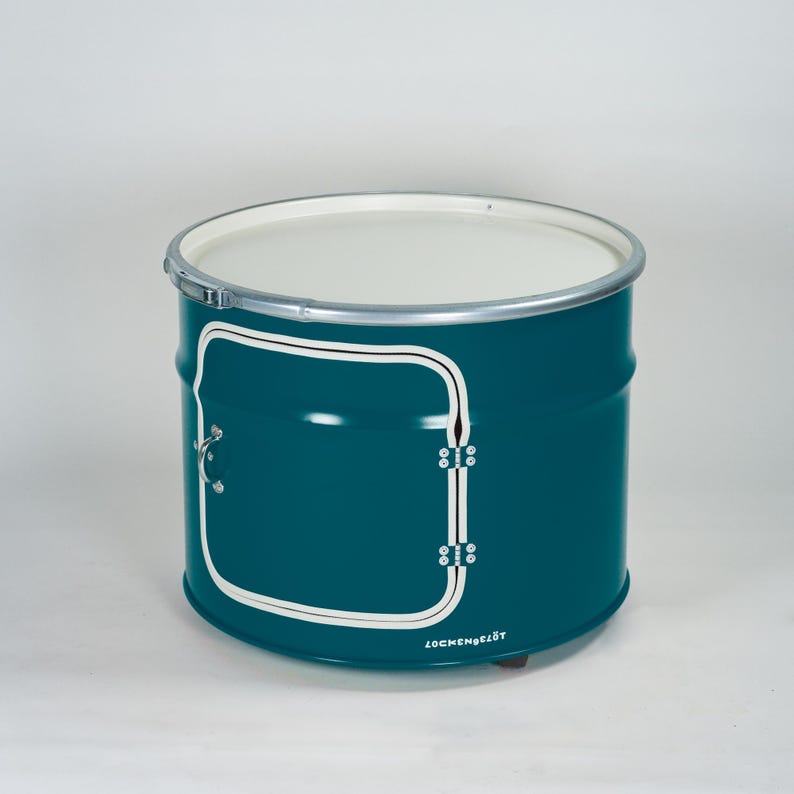 Puede incluir: Un mueble cil&iacute;ndrico de metal en color verde azulado con una parte superior circular blanca, un borde plateado y un dise&ntilde;o de puerta cuadrada delineada en blanco en el frente. Un peque&ntilde;o tirador plateado est&aacute; fijado a la puerta y la palabra LOCKENGELOT est&aacute; impresa en blanco.