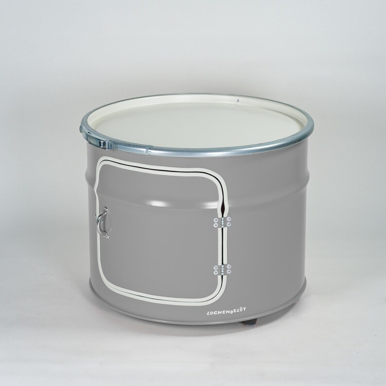 Puede incluir: Un tambor de almacenamiento cil&iacute;ndrico de metal gris con una parte superior plana blanca, un borde de metal plateado y una puerta cuadrada con esquinas redondeadas delineadas en blanco. La puerta incluye un asa y bisagras plateadas, con el texto LOCKENGELOT.