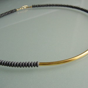 Collar de hematita gris mate, con elemento bañado en oro, minimalista y sencillo.