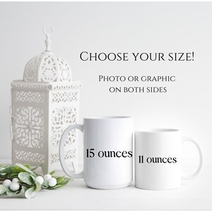 Może przedstawiać: Dwa białe ceramiczne kubki, jeden z napisem "15 uncji", a drugi "11 uncji", są pokazane. Tekst "CHOOSE YOUR SIZE! PHOTO OR GRAPHIC ON BOTH SIDES" znajduje się nad kubkami. W tle dekoracyjna biała latarnia i zieleń.