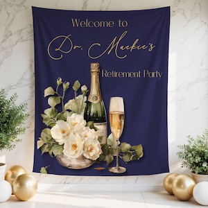 May include: Navy blue backdrop with gold text reading "Welcome to Dr. Mackie's Retirement Party." A champagne bottle, a glass of champagne, and white flowers are featured. The backdrop is decorated with gold and white balloons.