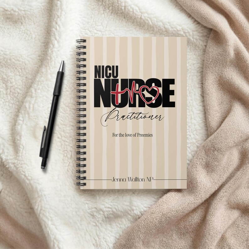 Op de afbeelding: Een spiraalgebonden notitieboek met een beige en witte verticaal gestreepte kaft. De tekst luidt NICU NURSE Practitioner, For the love of Preemies, en Jenna Wallton NP, met een rode hartvormige EKG-lijn. Een zwarte pen ligt ernaast.