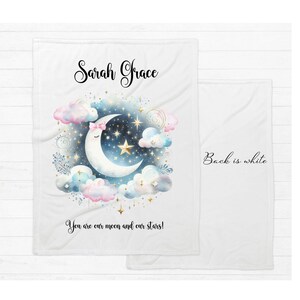 Puede incluir: Manta de beb&eacute; de franela blanca con un dise&ntilde;o de luna creciente y estrellas. La manta est&aacute; personalizada con el nombre "Sarah Grace" y el texto "You are our moon and our stars!" La parte posterior de la manta es blanca.