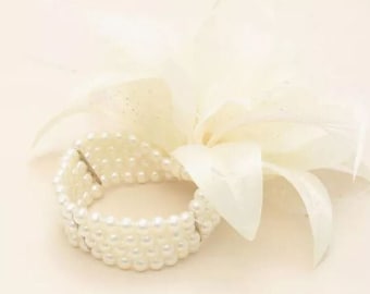 Cream feather and flower corsage on a 4 row pearl bead wristband