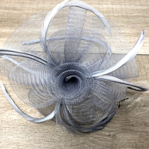 Silver grey centre net flower and feather fascinator on a matching coloured satin covered narrow aliceband