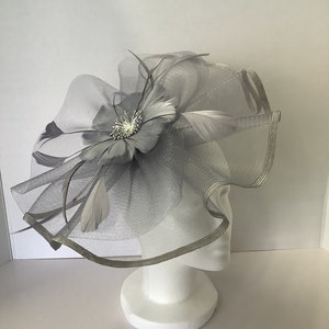 Grey large waved net and feather detail fascinator With band and clip fastener