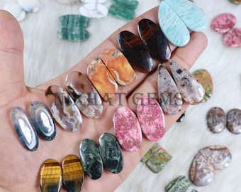 May include: Assortment of oval and teardrop shaped gemstone cabochons, including tiger's eye, green aventurine, and various agate varieties. The stones are polished and ready for jewelry making.