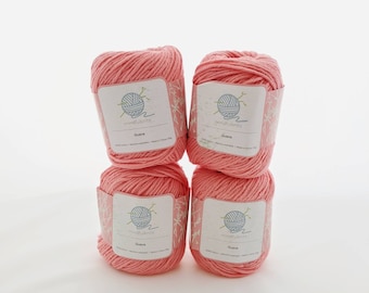 May include: Four balls of pink cotton yarn with the label "mindfulknits" and the word "Guava" printed on each label.