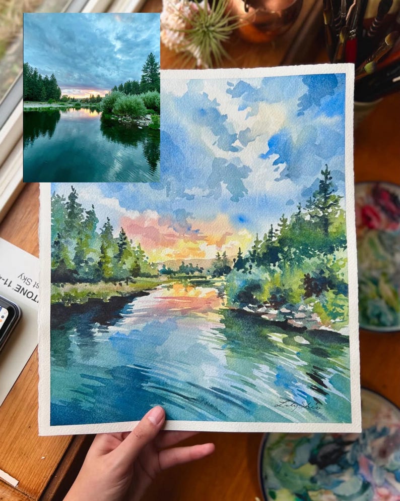 Puede incluir: Pintura acuarela de una escena de r&iacute;o con un cielo de puesta de sol, &aacute;rboles verdes y agua azul. La pintura est&aacute; sobre un fondo blanco.